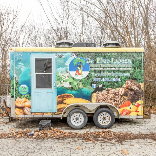 Da Blue Lagoon Jamaican food truck with vibrant graphics of food and a tropical scene.